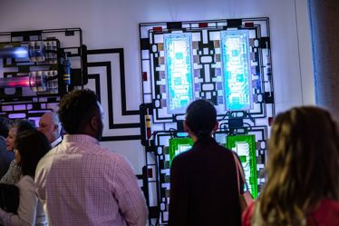 Patrons looking at a light up piece of art on a wall